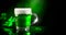 St. Patrick`s Day. Green beer pint over dark green background, decorated with shamrock leaves