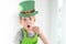 St Patrick`s Day holiday concept. Joyful emotional caucasian blond boy with green paper leprechaun hat with clover on