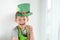 St Patrick`s Day holiday concept. Joyful emotional caucasian blond boy with green paper leprechaun hat with clover on white