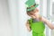 St Patrick`s Day holiday concept. Joyful emotional caucasian boy with green paper leprechaun hat with clover and glass