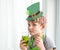 St Patrick`s Day holiday concept. Joyful emotional caucasian boy with green paper leprechaun hat with clover and glass