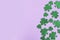 St. Patrick`s Day side border paper shamrocks on purple background.