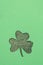 St. Patrick's day vertical background. Clover leaf shape from textured paper and glitter background with copy space