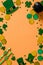 St Patrick`s Day vertical banner design. Irish leprechaun hats, pot of gold, and shamrock clover leaves on orange background with