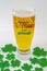 St patrick`s days Beer Pint with a green hat and clovers around