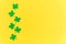 St Patricks Day background. Simply minimal design with green shamrock. Clover leaves isolated on yellow background. Symbol of