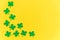 St Patricks Day background. Simply minimal design with green shamrock. Clover leaves isolated on yellow background. Symbol of