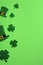 St Patricks Day frame of leprechaun hats and shamrock four leaves clover on green background. Saint Patrick`s day vertical banner