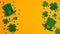 St. Patricks Day frame of shamrock leaf clovers, Irish elf hats and confetti on orange background. Flat lay, top view. Saint