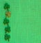 St. Patricks Day or Irish Green Shamrocks on Burlap Linen Background with copy space.  It`s square with a trendy flat layout