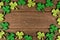 St Patricks Day shiny shamrocks frame over rustic wood