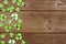St Patricks Day side border of paper button shamrocks, top view on a wood background with copy space
