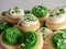 St Patrickâ€™s Day holiday frosted sugar cookies with green and white frosting and sprinkles with four leaf clover shamrocks for a