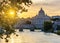 St. Peter\\\'s basilica dome and St. Angel bridge over Tiber river at sunset in Rome, Italy