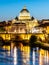 St Peters Basilica in Vatican and Ponte Sant`Angelo Bridge over Tiber River at dusk. Romantic evening cityscape of Rome