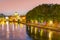 St Peters Basilica in Vatican and Ponte Sant`Angelo Bridge over Tiber River at dusk. Romantic evening cityscape of Rome