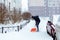 St. Petersburg, Russia - January 17, 2019: A man cleans snow in the yard with a shovel after a heavy snowfall