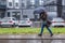 St. Petersburg, Russia June 2019-Murino district, heavy rain, flooding, a woman with an umbrella goes and looks in the phone