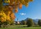 St Sixtus church Schliersee, rural autumnal landscape with maple tree and colorful leaves