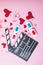 St. Valentine`s day Movie night concept. Popcorn, 3d glasses clapper board on pink  background. Cozy holiday plans for lovers