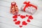 St. Valentine`s Day: one carved candle, hearts from felt and a gift with red tape.