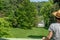 Staatspark FÃ¼rstenlager with Buildings and meadow, Woman with brown hair and straw hat standing in front, looking at view,