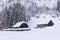 Stable, cowshed for cows and horses. Farm building built of stones and wood. Winter mountain landscape in the Alps.