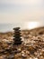 Stable pebble tower on the beach at sunset. Vertical format. The concept of balance and tranquility.