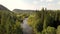 A stable shot from a drone over a river and forest.