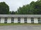 Stables at a horse track with trees and dirt road