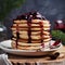 Stack of american pancakes or fritters with strawberry and blueberry jam in white plate on wooden rustic table decorated Christmas