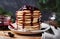 Stack of american pancakes or fritters with strawberry and blueberry jam in white plate on wooden rustic table decorated Christmas