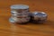 A stack of assorted coins on the wooden table