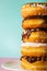 Stack of assorted donuts on pastel blue and pink background