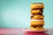 Stack of assorted donuts on pastel blue and pink background