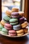 A stack of assorted macarons on a platter, traditional French dessert cookies