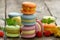 Stack of baked multicolored macarons and different flavors on a gray wooden table