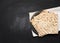 Stack of baked square matzo on a black wooden background