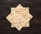 Stack of baked square matzo on a brown wooden background