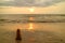 Stack of balanced pebble stones on the sunset beach against splashing waves