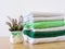 Stack of bath towels on light wooden background closeup.Pile of rainbow colored towels.Top view.