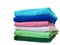 Stack of bath towels on light wooden background closeup.Pile of rainbow colored towels.Top view.