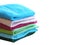 Stack of bath towels on light wooden background closeup.Pile of rainbow colored towels.Top view.