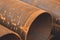 Stack of big rusty steel pipe at a construction site. Installation of pipeline. Metal water tubes. Industrial concept