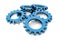 Stack of blue colored metallic cogwheels on white surface