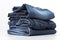 Stack of blue denim clothes on white background, jeans and jacket