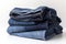 Stack of blue denim clothes on white background, jeans and jacket