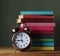 Stack of books and an alarm clock. Back to school.