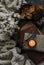 Stack of books, candle, autumn leaves, knitted plaid - cozy home still life on a dark background, top view