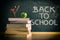 Stack of books on class table and chalkboard with message